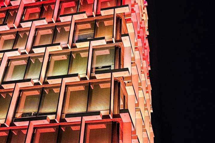 Modern building with colorful illuminated windows against a night sky.